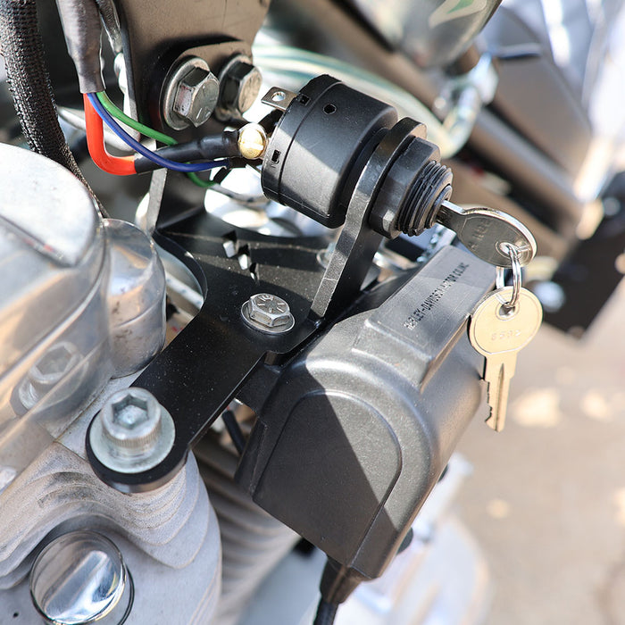 Close-up of a motorcycle ignition switch with keys and wiring.