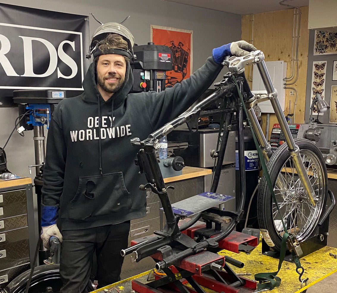 Man standing with motorcycle frame