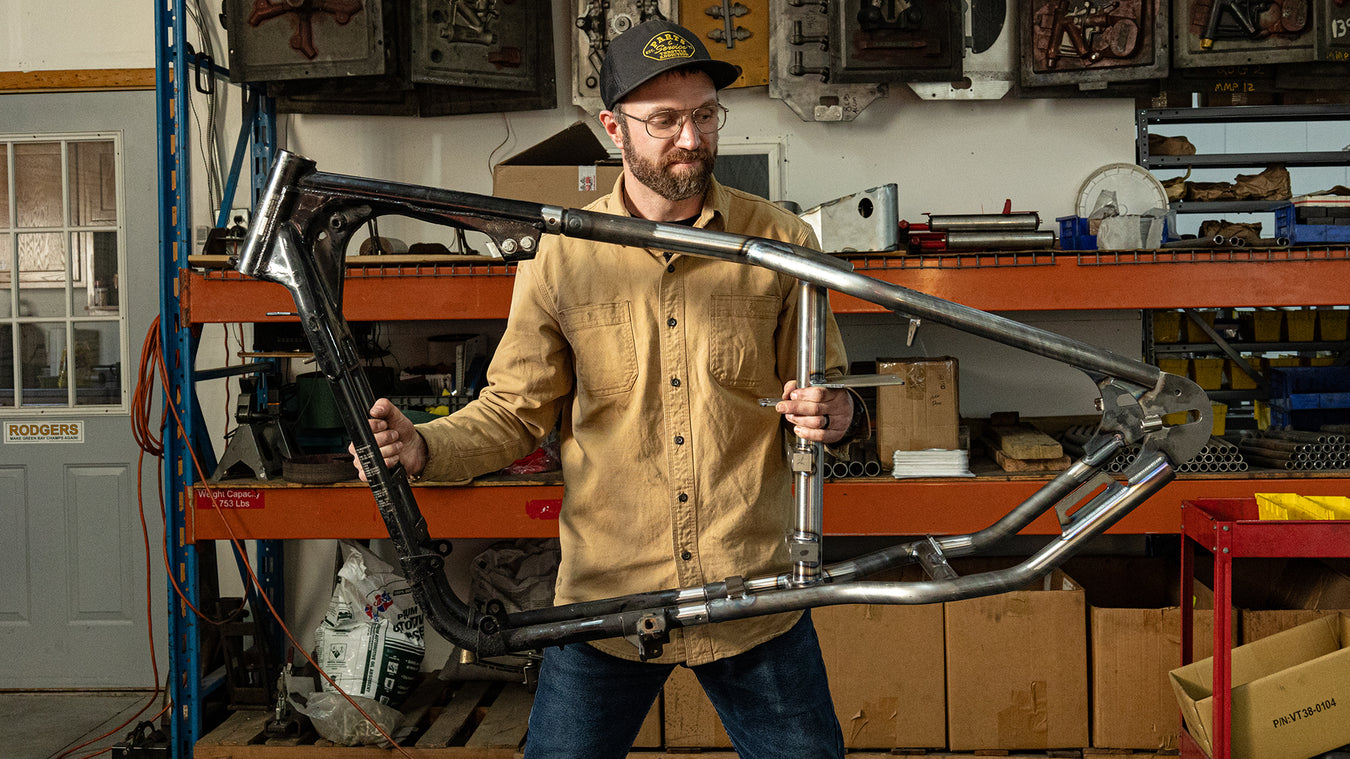 Man holding up a motorcycle frame.