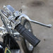 Close-up of a motorcycle handlebar with black grip and chrome lever on a blurred background