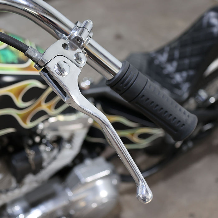 Close-up of a motorcycle handlebar with flame design in the background