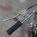 Close-up of a motorcycle handlebar with black grip and silver lever on a blurred background