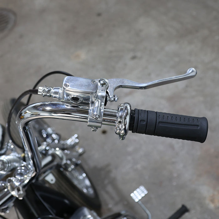 Close-up of motorcycle handlebar with chrome controls on a concrete surface