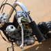 Close-up of a motorcycle handlebar with chrome lever and black grip on a blurred background