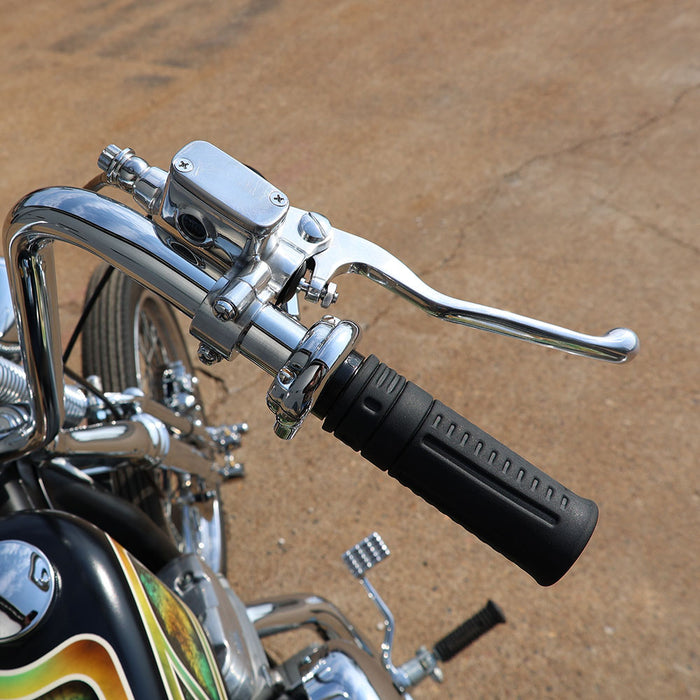 Close-up of a motorcycle handlebar with chrome controls and black grips on a brown background