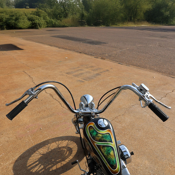 Motorcycle with a colorful fuel tank on a paved road with greenery in the background