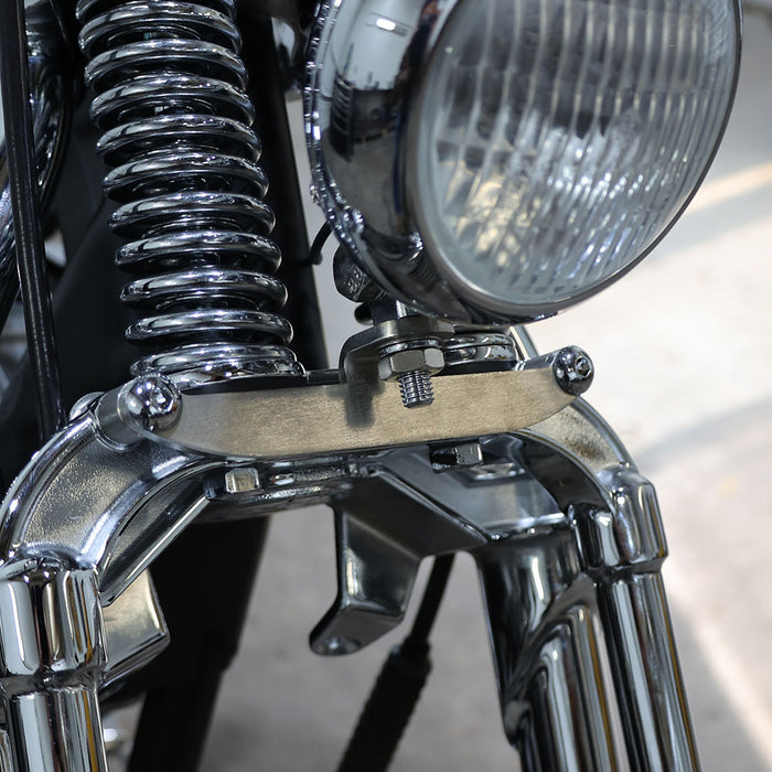 Close-up of a motorcycle headlight and chrome parts on a blurred background