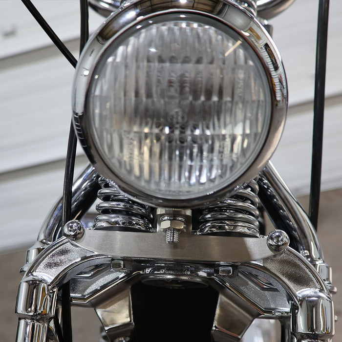 Close-up of a motorcycle headlight with chrome finish