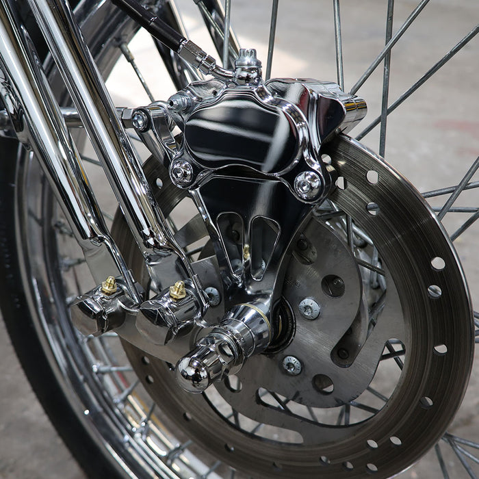 Close-up of a motorcycle wheel with chrome suspension and disc brake.