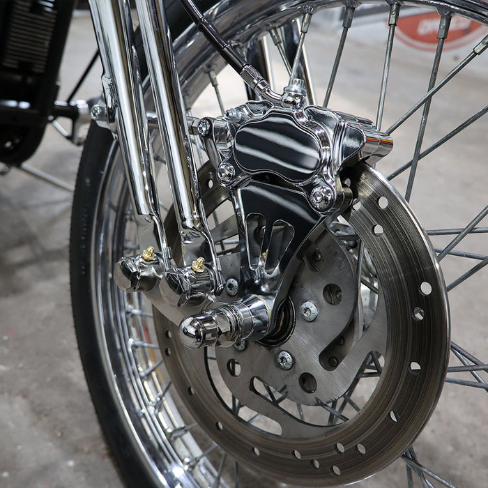 Close-up of a motorcycle wheel with chrome components on a blurred background