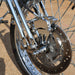 Close-up of a motorcycle wheel with metallic components on a blurred background