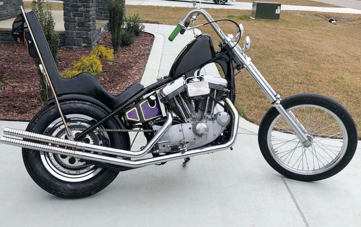 black sportster chopper in driveway with purple paint on tank and king and queen seat throttle addiction