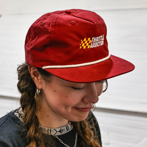Person wearing a red cap with 'Throttle Addiction' logo on a white background