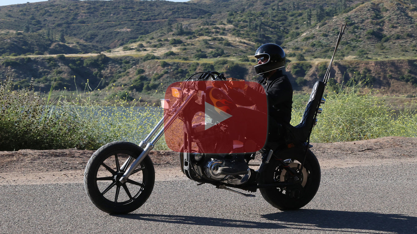 Man riding a chopper motorcycle with canyon in background, Youtube logo on photo