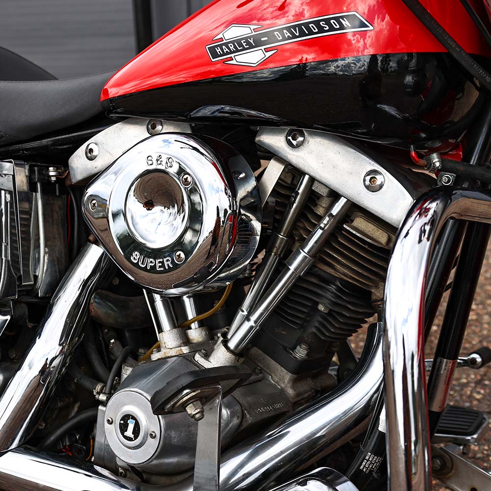 Close-up of a Harley Davidson motorcycle engine with red gas tank.
