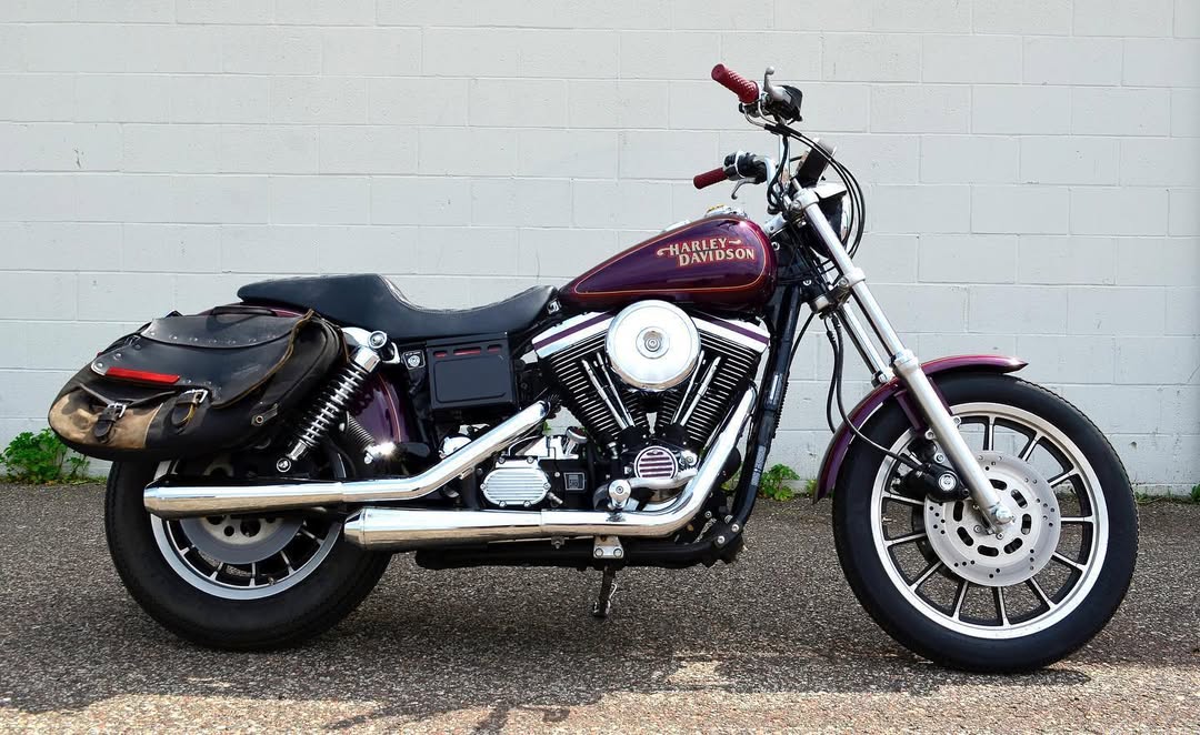 Harley-Davidson motorcycle parked on a concrete surface with a white brick wall in the background.
