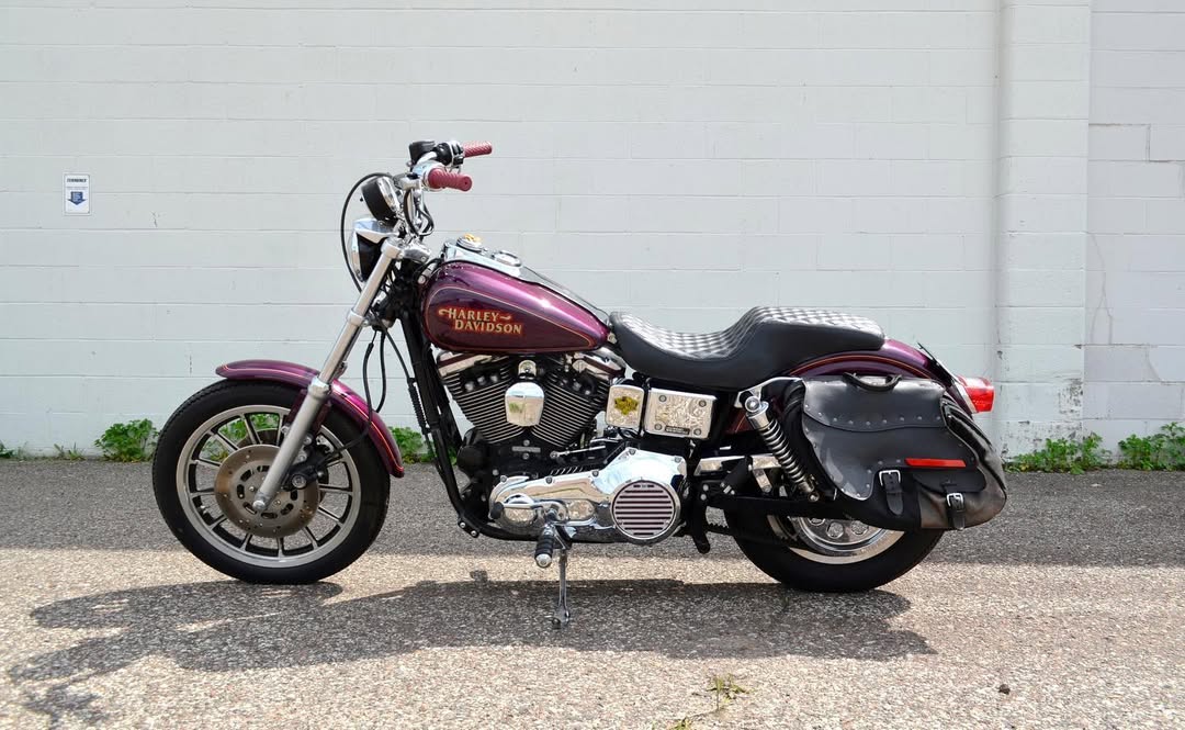 Harley Davidson motorcycle parked on a concrete surface with a light gray wall in the background