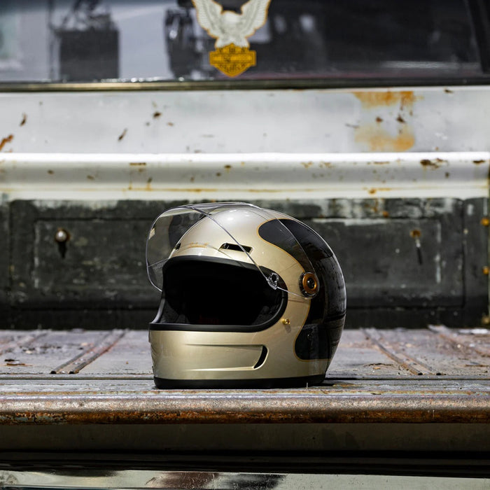 Champagne and charcoal helmet on a rusty surface