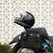 Black motorcycle helmet on a motorcycle with a geometric patterned wall in the background